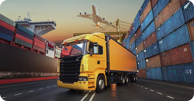 Cargo truck moving beside stacked shipping containers